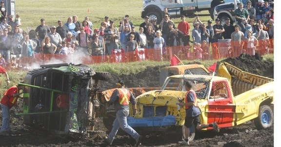 Ole Lotsburg&#8217;s truck is pushed on its side as volunteers rush to the scene. After getting the truck back on four wheels, Lotsburg continued the match. Also pictured are 
