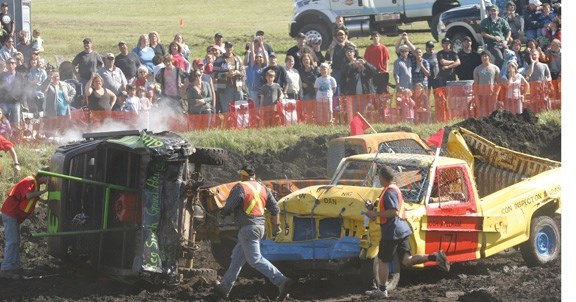 Ole Lotsburg&#8217;s truck is pushed on its side as volunteers rush to the scene. After getting the truck back on four wheels, Lotsburg continued the match. Also pictured are 