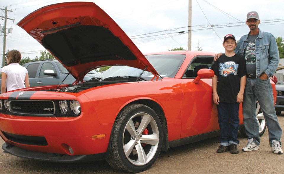 Robin Highberg and his son Robert in front of a 2009 Challenger at the Dairy Queen Miracle Treat Day car show on August 12. A dollar for every Blizzard sold went to the