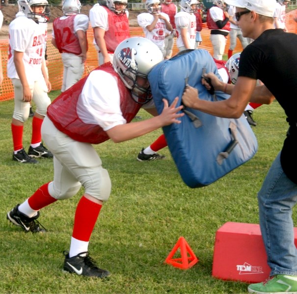 A Bandit hopeful (left) uses his head to push back Voyageurs quarterback Jeremy Fagnan at The Bandits first practice of the season on August 18.