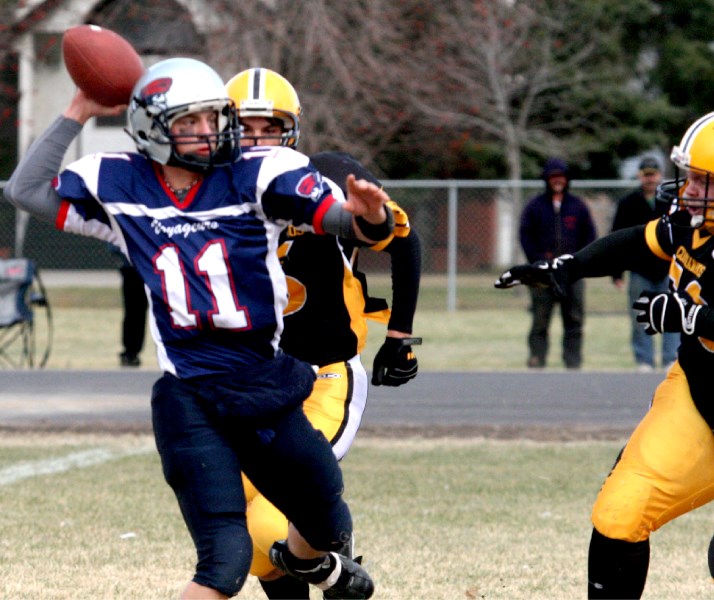Voyageurs quarterback Jeremy Fagnan remains focused, with two Wainwright defenders bearing down on him, and still gets the ball away. The Voyageurs beat Wainwright 8-5 in