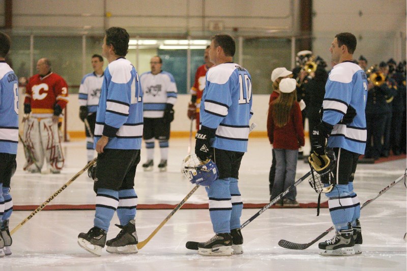 Players stand on ice for the national anthem before facing off at the second annual Afterburner Cup at 4 Wing in Cold Lake.