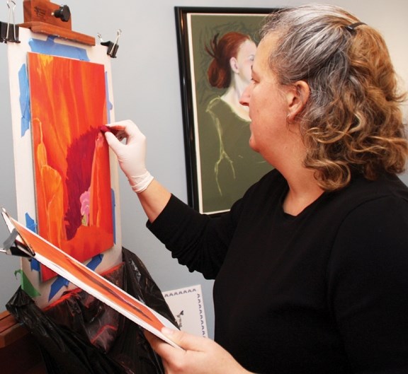 Terri Stelfox paints a poppy Nov. 19 during her residency at Café Impromptu.