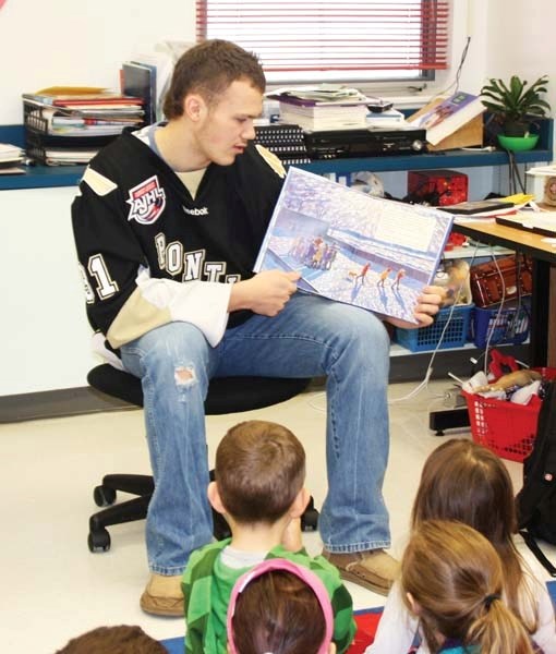 Pontiacs goalie Connor Creech reads a hockey story to kindergarten students at Notre Dame Elementary Nov. 30.