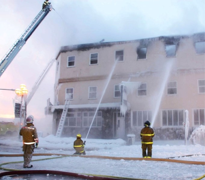 Firefighters work to put out a fire that broke out at the Bonnyville Hotel Dec. 16.