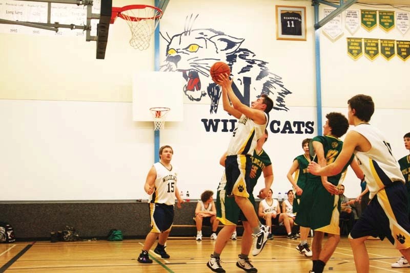 NDHS guard Jonathan Cardinal flies through the air and makes the basket against William E. Hay School at the Roadrunner Classic this weekend. The NDHS girls won the