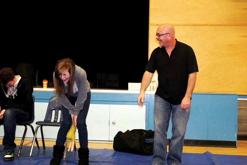 Mitch Dorge has local high school student Carlie Sylvestre thrusting a chicken as part of his presentation on March 15.