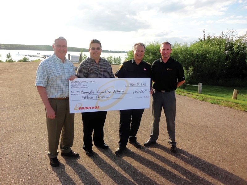 (Left) Ian Melligan, manager of pipeline services for Enbridge&#8217;s western region office and (far right) Craig Matwick, Enbridge community relations advisor, present a