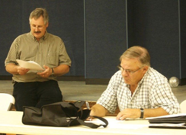 After collecting residents&#8217; concerns about the proposed work camp, David McDaniel (left) reviews the group&#8217;s rebuttal, while MD Coun. Glen Johnson takes notes at