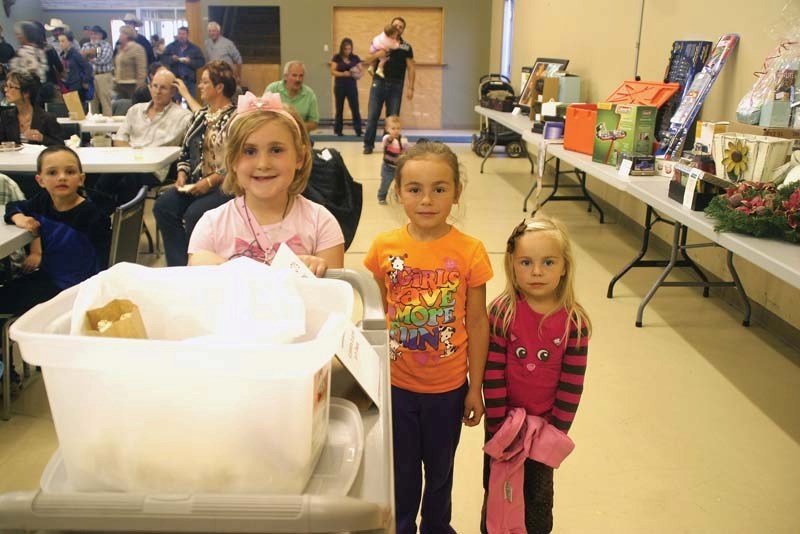 (Left &#8211; right) Zoe Maclellan, Madison Bureau, and Emma Grace Bureau push a popcorn cart through the crowd accepting donations for Oksanah Watton and her family at the