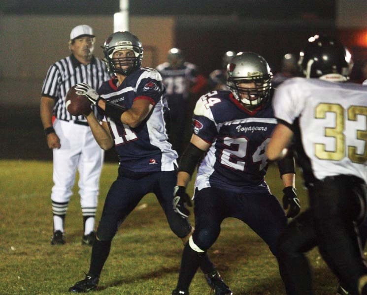 With a block from Voyageurs running back Michael Zelisko (24) quarterback Jeremy Fagnan (11) looks for an open man down field. The Voyageurs played the Royals in front of