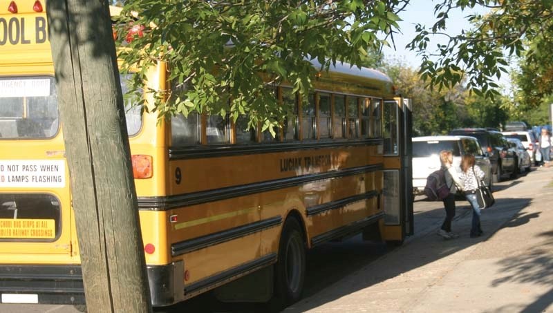 A school bus drops children off outside Duclos School earlier this year. Local school board officials are worried about the &#8220;critical shortage&#8221; of local drivers..