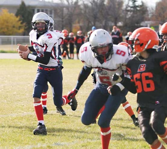 With a block from Justin Church (5) Bandits quarterback Gregory Godziuk (3) makes a run for it in Saturday&#8217;s 55-0 over the St. Paul Lions at Walsh Field.