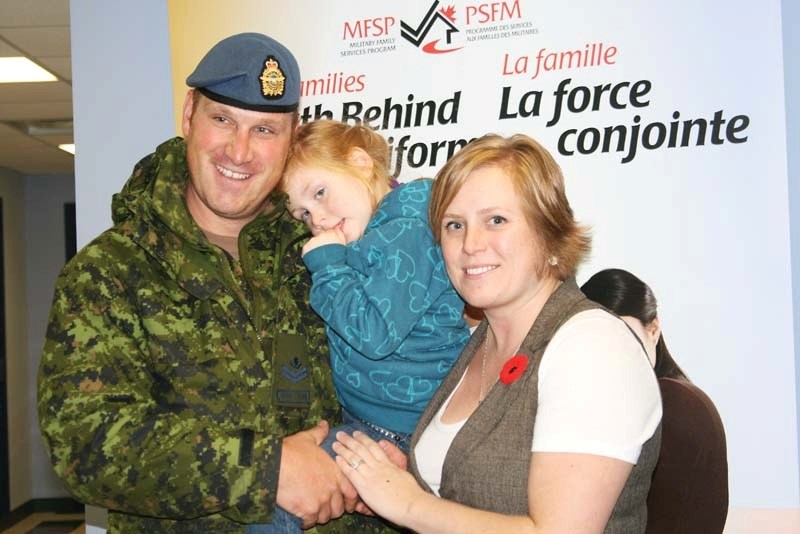 Master Cpl. Will Bown and wife Joelene Sexsmith hold daughter Adelle after the family was reunited early Saturday morning.