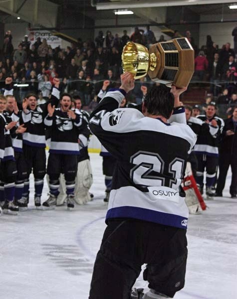 Cold Lake Ice captain Craig Wowk raises the league championship trophy to celebrate with awaiting teammates after the Ice defeated the Killam Wheat Kings in four straight