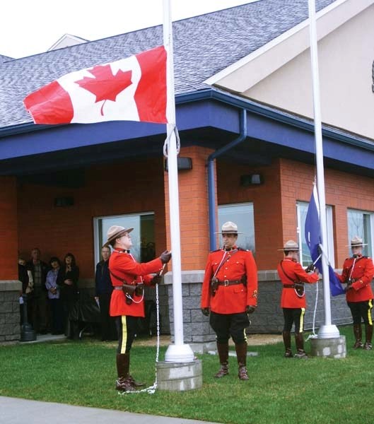 Members of the Bonnyville RCMP raise the Canadian Flag as part of the ribbon cutting ceremony on Friday.