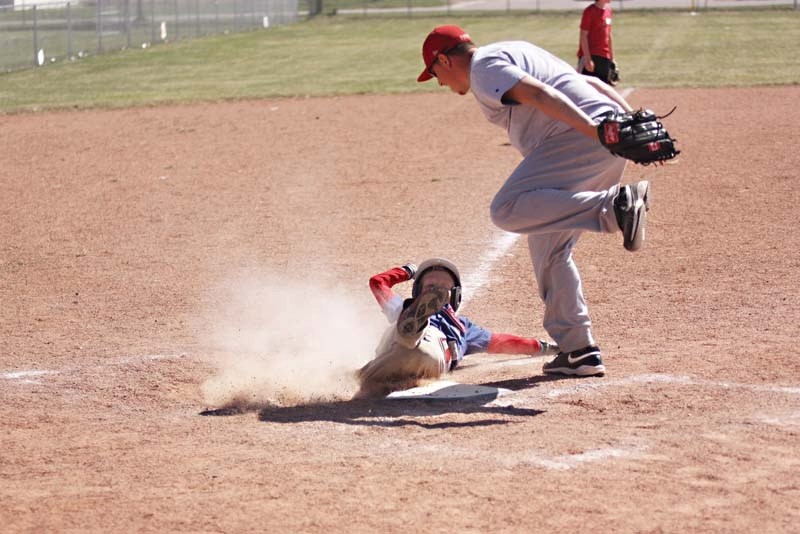 Nine-year-old Jordan Breen slides into home just under the tag of professional ball player and camp coach Greg Dumouchel during the final day of the spring ball camp held in