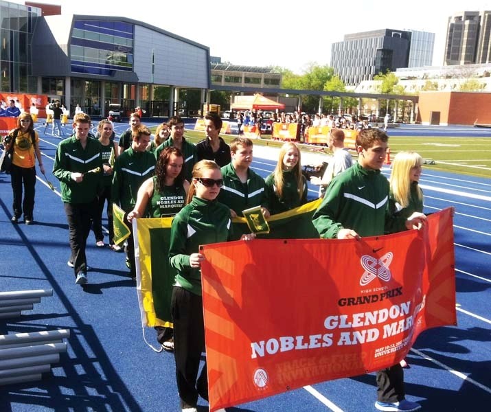 Members of the Glendon School track team carry banners as they enter the University of Toronto Stadium for the Nike High School Grand Prix on May 11.