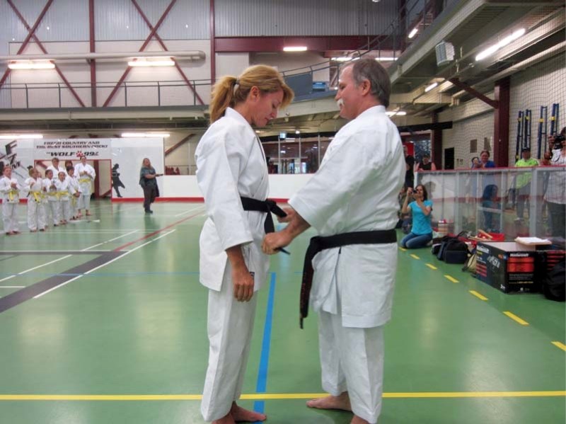 Corne Muller (left) receives her black belt from Sensei Carry Grant during the Bonnyville Karate-Do&#8217;s year-end windup celebration at the Centennial Centre on May 29.
