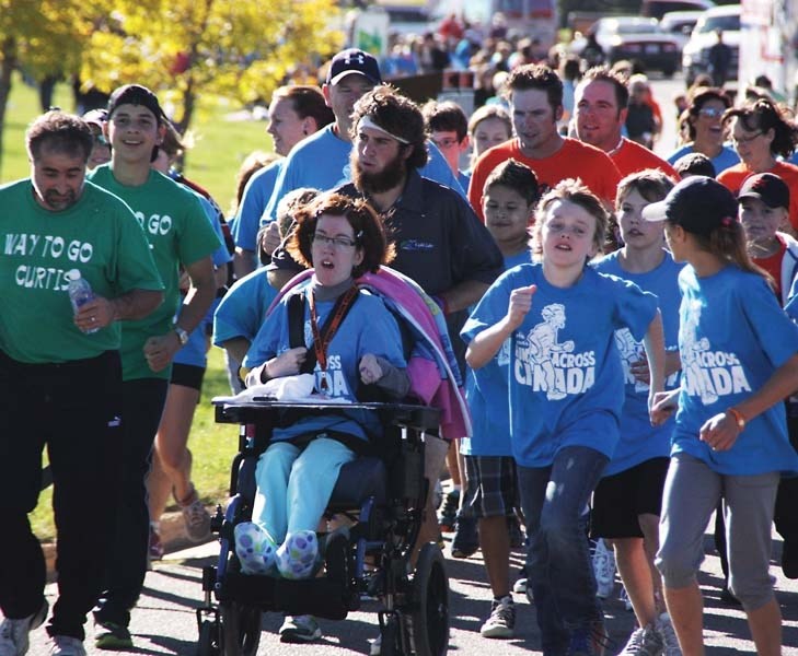 Curtis Hargrove (middle) pushes local supporter Sandra Shipclark during his run through his hometown of Cold Lake. Hargrove arrived in Cold Lake on Sept. 21 for a celebration 