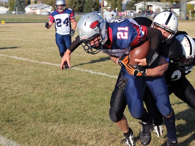 Bonnyville Voyageurs quarterback Jerad Churko stretches for extra yards just as he is tackled by two St. Paul Lions defenders during the game this past Friday in St. Paul.