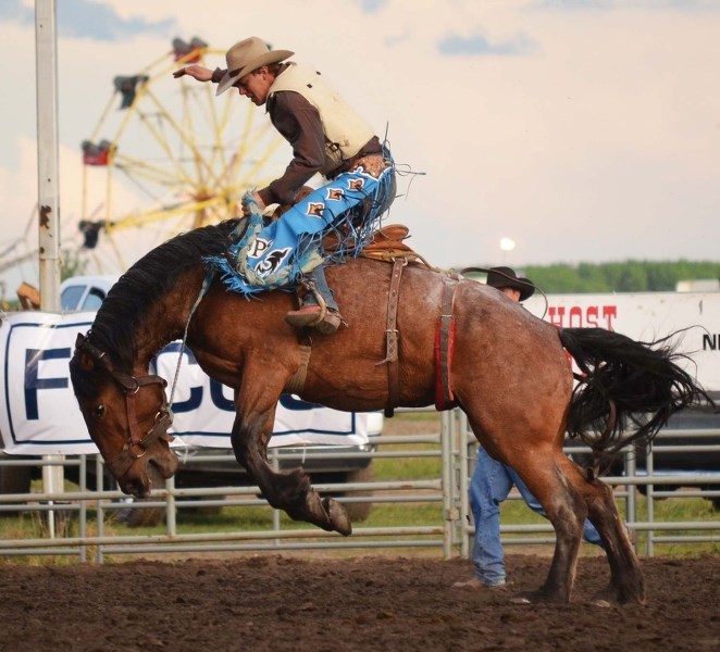 Wyatt Thurston, a native of Big Valley, AB struggles to stay on his horse during Saturday&#8217;s saddle bronc competition at the 2013 Bonnyville Pro Rodeo.