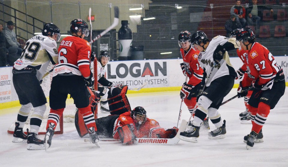 Spencer Foo of the Bonnyville Pontiacs jams at the puck, while Whitecourt goaltender Tanner Kovacs sprawls to cover it up. Whitecourt went on to defeat the Pontiacs 6-4 at