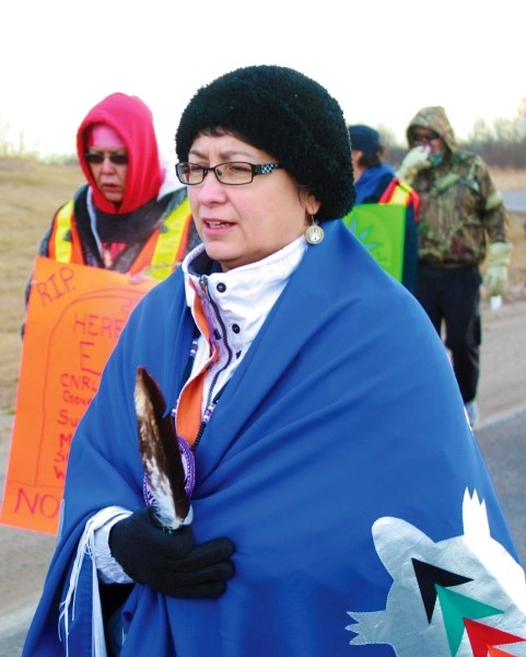 One of the organizers the Idle No More ceremonial walk, Shannon Houle, Saddle Lake Cree Nation councillor, carries an eagle feather with her as about 30 people walk along