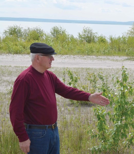 Peter Crown points to land that was once covered by Muriel Lake. In the background, the lakeshore can be seen receded back several metres.