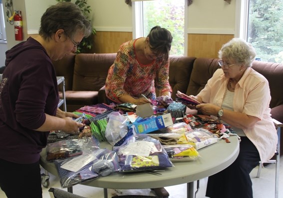 (left to right) Michelle Green, Larisa de Freitas and Trudie Nel put together kits of feminine hygiene products to send to girls overseas.