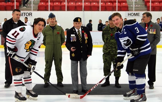 In honour of Remembrance Day, Cold Lake Ice captain Kurt Franklin (front right), Saddle Lake Warriors captain Silas Makokis (front left) participate in a ceremonial puck drop 