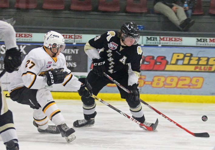 Bobby McMann battles for the puck during third period action against the Olds Grizzlys on Jan. 30.