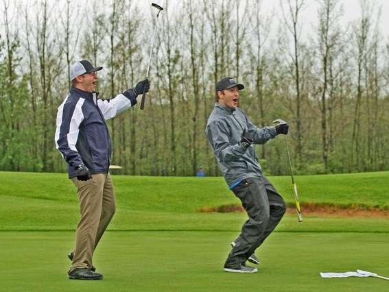 Justin Fontaine and Lucas Isley celebrate after Isley managed to make a 20-yard putt on the 12th hole during the first annual Pontiacs Alumni Golf Tournament on May 28