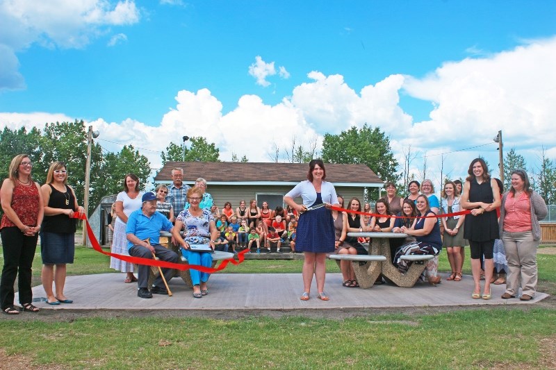 Students and staff gather around Iron River School&#8217;s new picnic benches to commemorate the school&#8217;s 60th aniversary and to remember loved teacher David Sarawanski