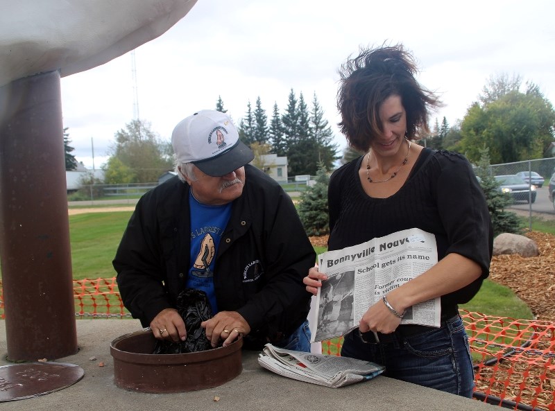Former Glendon mayor Johnnie Doonanco and current Mayor Laura Papirny pull out newspapers from 1991 that were in the pyrogy time capsule, which was opened during the 25th