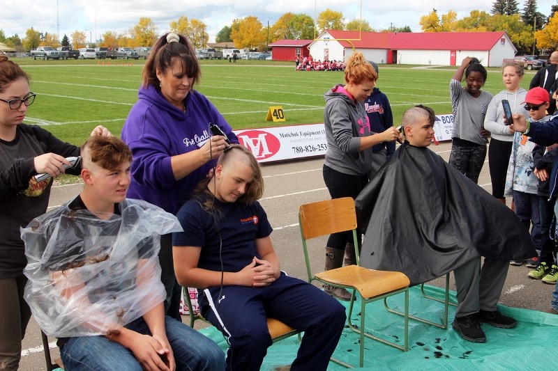 Members of the Voyageurs football team shave their heads at the annual Scott MacDonald Memorial on Sept. 17. (left) Tyler Funk and (right) Triston Smith, who had grown his