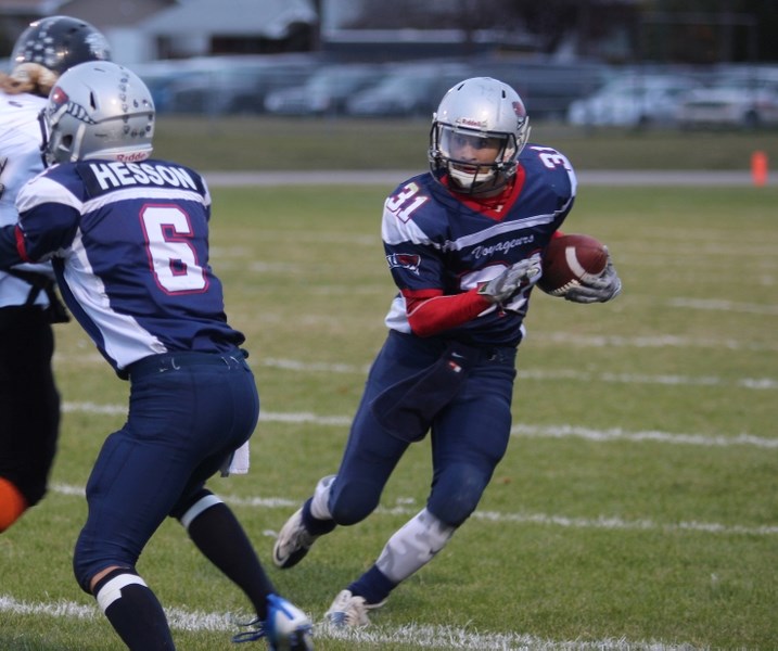 Reid Skrypichayko (31) recieves some blocks from his team as he carries the down the field