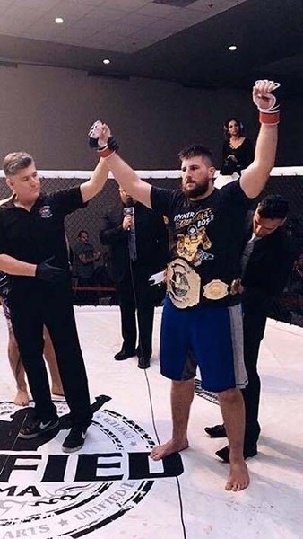 Tanner Boser celebrates his title defence at Unified 28 in Edmonton