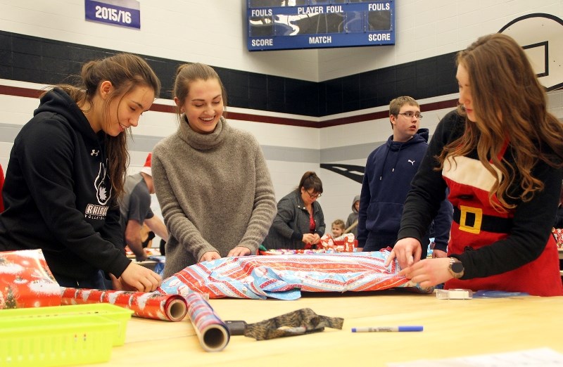 (left to right) Lisa Ference, Taryn Yaceyko, and Lauren McGhie are busy wrapping presents at the annual BCHS Santa&#8217;s Elves Wrapping Party on Thursday, Dec. 15. This