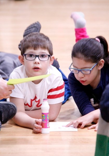 Drew Worthman, 6, and Addison Houle, 6, work on filling out their card in Word Bingo.