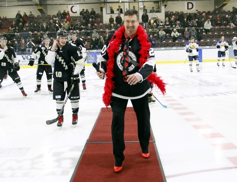 Mayor Gene Sobolewski makes his way off of the ice in his red high heels, as he joins 19 other men taking part in the first Walk a Mile in Her Shoes event on Sunday, Feb. 26.