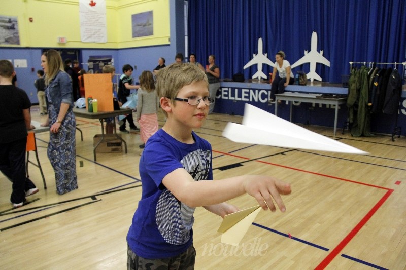 Second-grader Hunter Owens tosses a paper airplane for one of the exhibits.