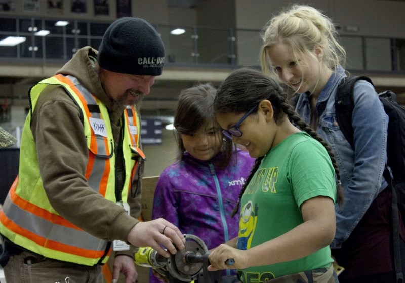 Demonstrator Chris Keep from Cold Lake Public Works gives students Sadie Desjarlais, Grayson Scannie and their teacher Alysha Chiu a hands-on look at how torque works.