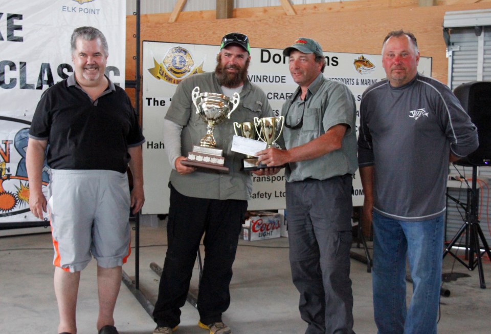(above) First place winners with a record-breaking weigh in, Trevor Moar and Mark Holzwarth accept their trophy from George Hahn, organizer, and Elk Point Lions Club