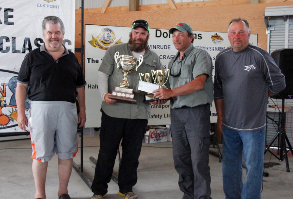 (above) First place winners with a record-breaking weigh in, Trevor Moar and Mark Holzwarth accept their trophy from George Hahn, organizer, and Elk Point Lions Club