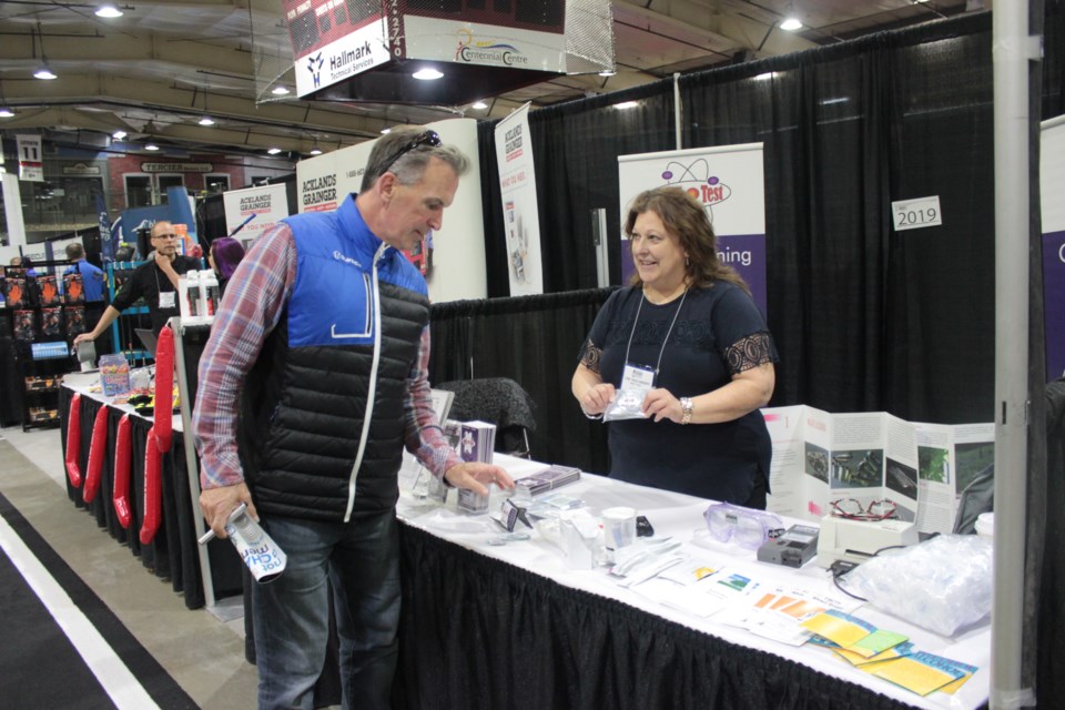Lina Yadlowsky, owner of Multi Test, shows Dan Douglas her products and services.