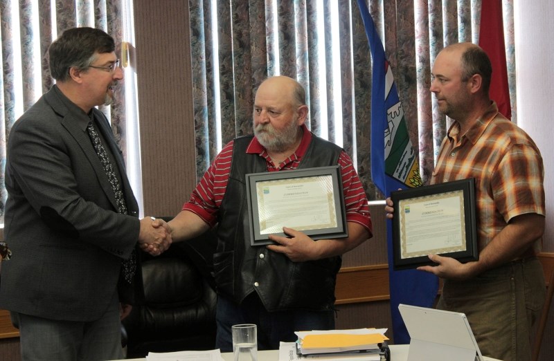 Bonnyville Mayor Gene Sobolewski (left) presents Town of Bonnyville employees Larry Resch (middle) and Rondan Leepart (right) with plaques.