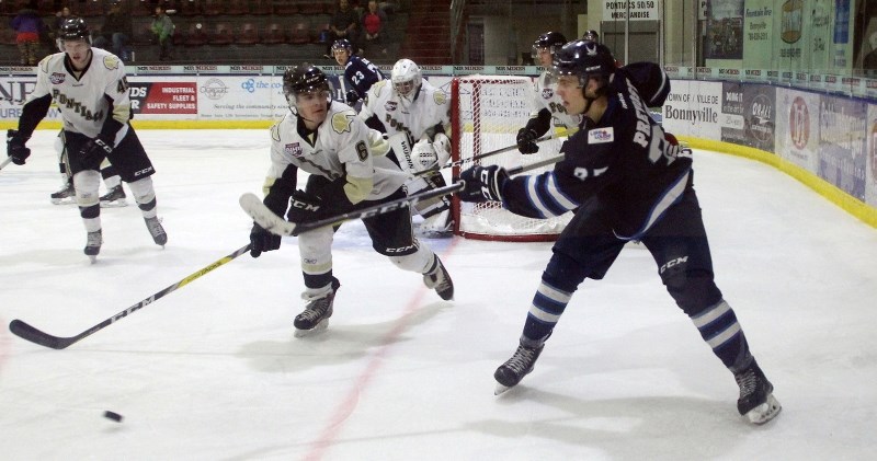 Pontiacs defenceman Ryley Hogan chases Canmore Eagles forward Coy Prevost into the corner during the Pontiacs 4-2 loss against the Eagles on Saturday, Oct. 14 at the R.J.