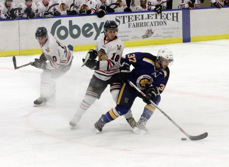 Bonnyville Pontiacs forward Devon Kalinski guards the puck from Westlock Warriors defenceman Samuel Moisan.