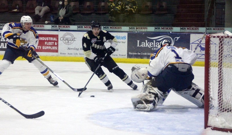 Pontiacs forward Derek Brown breaks in on Fort McMurray Oil Barons goaltender Chris Curr.